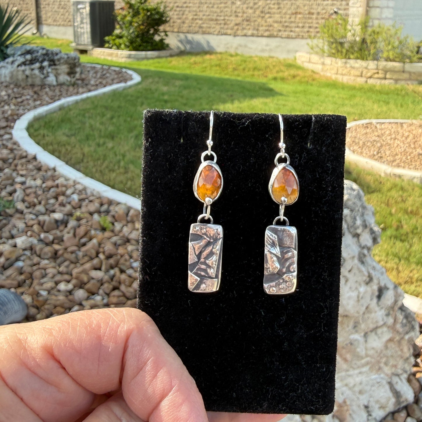 Hessonite garnet and etched silver botanical dangle earrings on black velvet display card