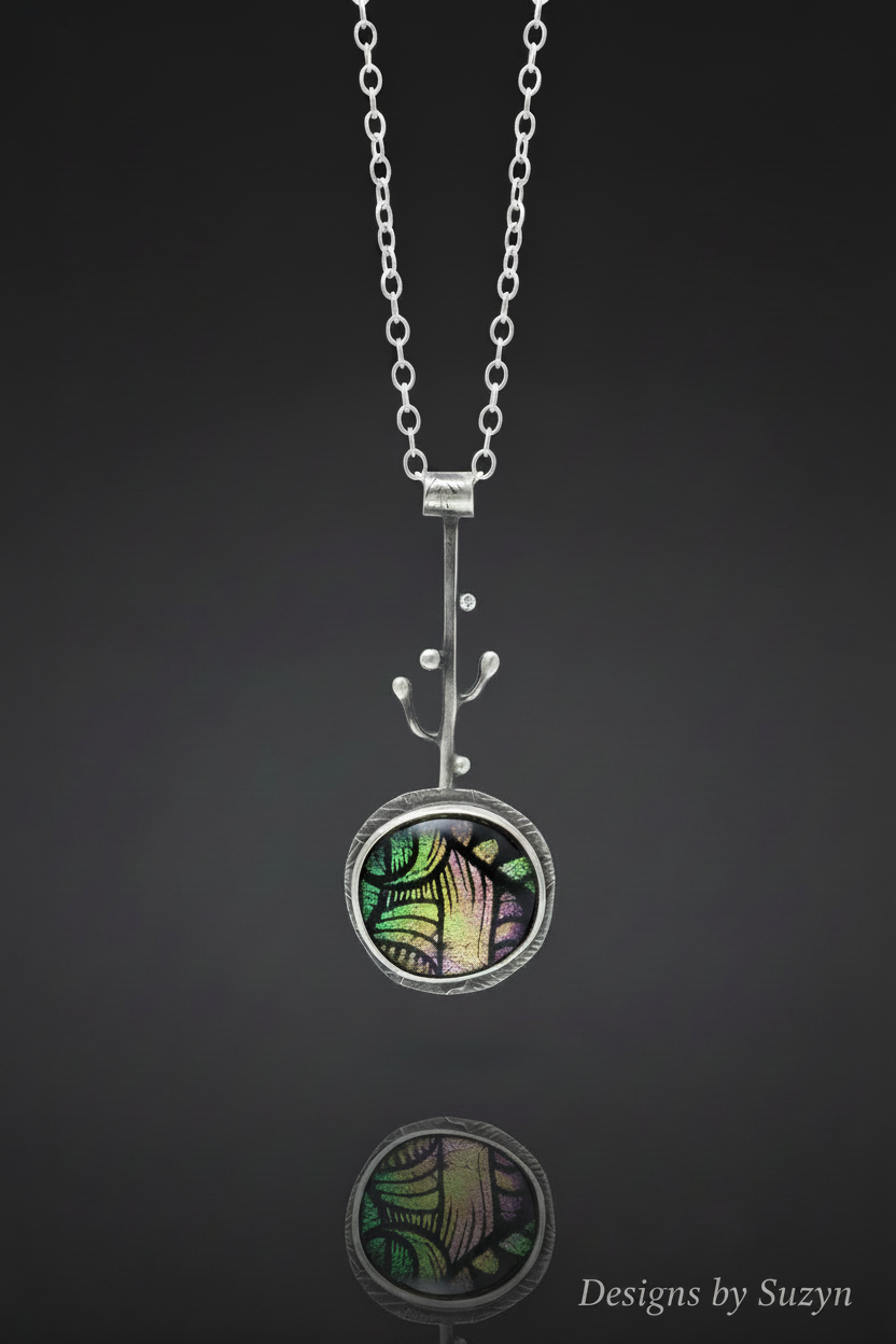 Dichroic glass pendant necklace on charcoal background with reflection and Designs by Suzyn watermark