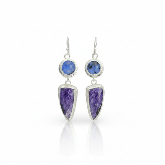 Kiln cast fused glass and charoite sterling silver earrings standing upright on white surface with soft reflection beneath